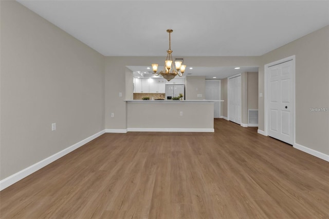 601 Shreve St Unit 64C, Punta Gorda, FL 33950 - unfurnished living room featuring a chandelier, light wood-style flooring, baseboards, and recessed lighting