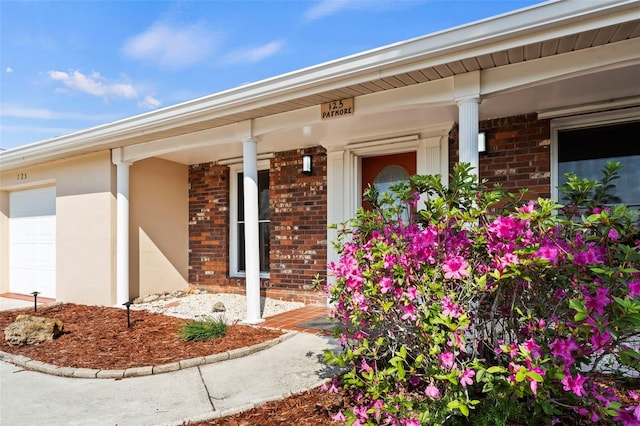 125 Small St SE, Port Charlotte, FL 33952 - entrance to property with brick siding, covered porch, and a garage