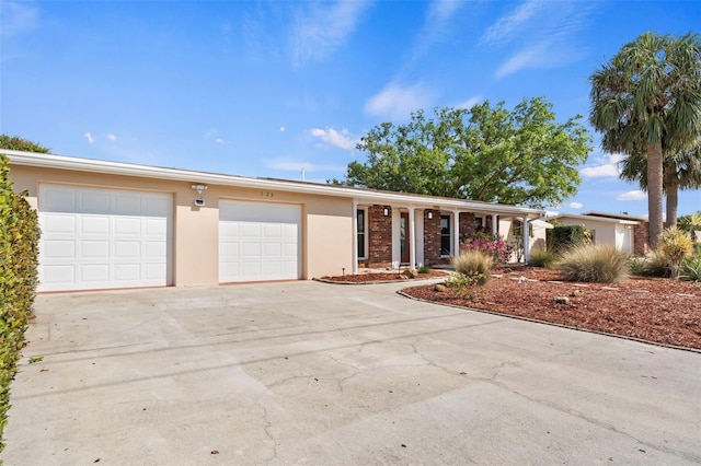 125 Small St SE, Port Charlotte, FL 33952 - view of front of house featuring stucco siding, concrete driveway, an attached garage, and covered porch