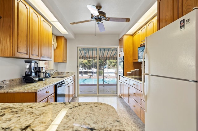 125 Small St SE, Port Charlotte, FL 33952 - kitchen featuring freestanding refrigerator, dishwasher, a ceiling fan, dark speckled floor, and a sink