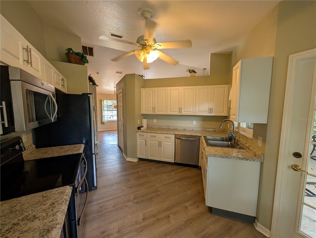4205 Simkins Ave, North Port, FL 34286 - kitchen with appliances with stainless steel finishes, a sink, ceiling fan, white cabinets, and wood finished floors