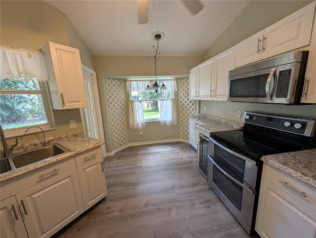 4205 Simkins Ave, North Port, FL 34286 - kitchen with stainless steel appliances, vaulted ceiling, a sink, white cabinets, and ceiling fan