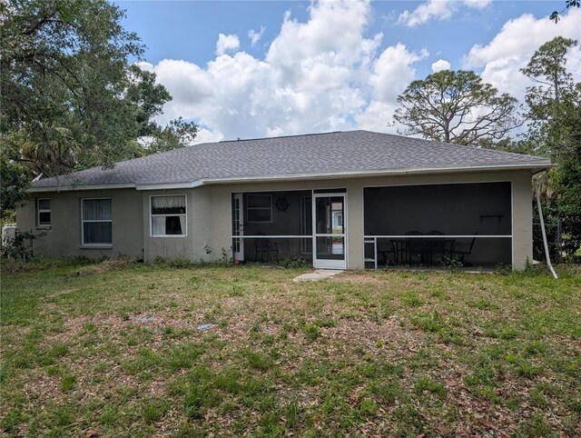 4205 Simkins Ave, North Port, FL 34286 - rear view of property featuring a sunroom, a lawn, stucco siding, and roof with shingles