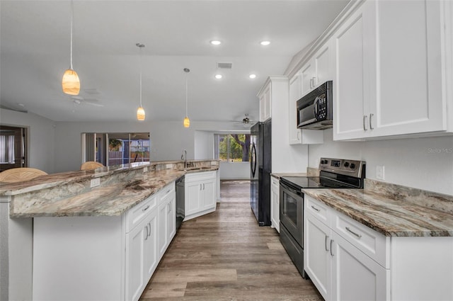 1210 Mccrory St, North Port, FL 34286 - kitchen featuring black appliances, a sink, white cabinetry, wood finished floors, and recessed lighting