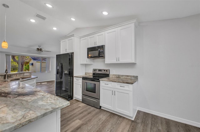 1210 Mccrory St, North Port, FL 34286 - kitchen featuring black appliances, a sink, white cabinets, baseboards, and vaulted ceiling