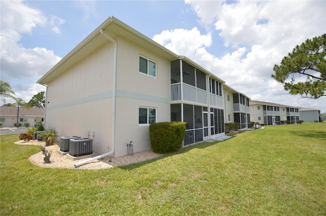 12538 SW Kingsway Cir Unit 1602, Lake Suzy, FL 34269 - back of property with central AC unit, a yard, a sunroom, and stucco siding