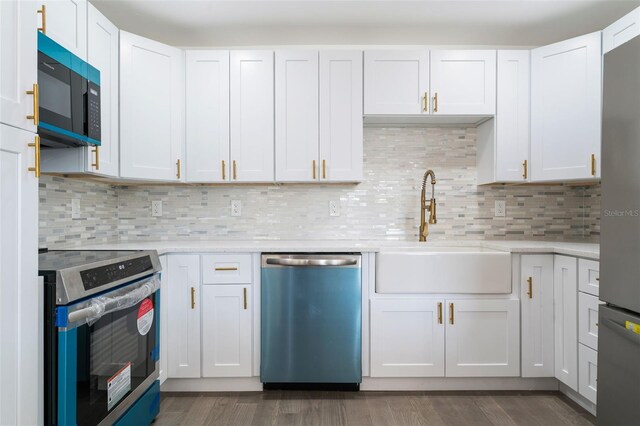1231 Beacon Dr, Port Charlotte, FL 33952 - kitchen featuring appliances with stainless steel finishes, a sink, light countertops, and dark wood-style flooring