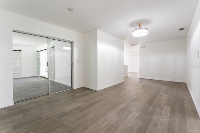 1231 Beacon Dr, Port Charlotte, FL 33952 - unfurnished room featuring wood finished floors, baseboards, and a barn door