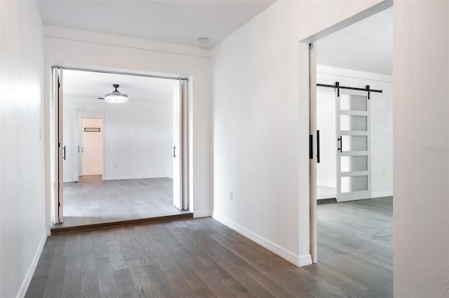1231 Beacon Dr, Port Charlotte, FL 33952 - hall with wood finished floors, a barn door, and baseboards
