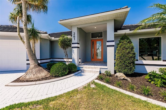 261 Venezia Ct, Punta Gorda, FL 33950 - property entrance featuring stucco siding, a garage, and decorative driveway