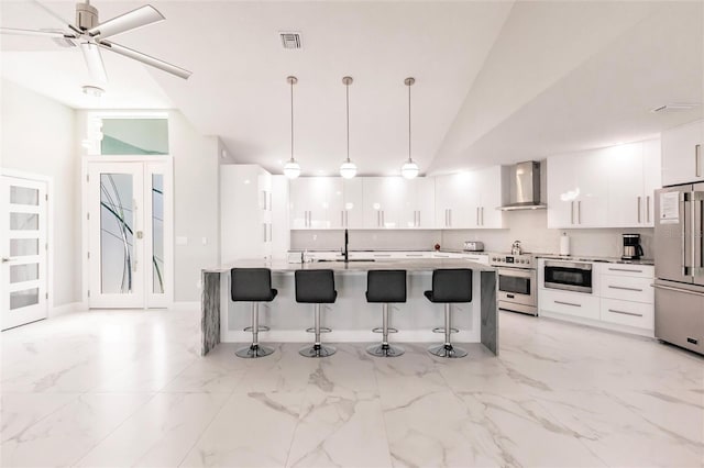 261 Venezia Ct, Punta Gorda, FL 33950 - kitchen featuring appliances with stainless steel finishes, wall chimney range hood, modern cabinets, a breakfast bar area, and white cabinets