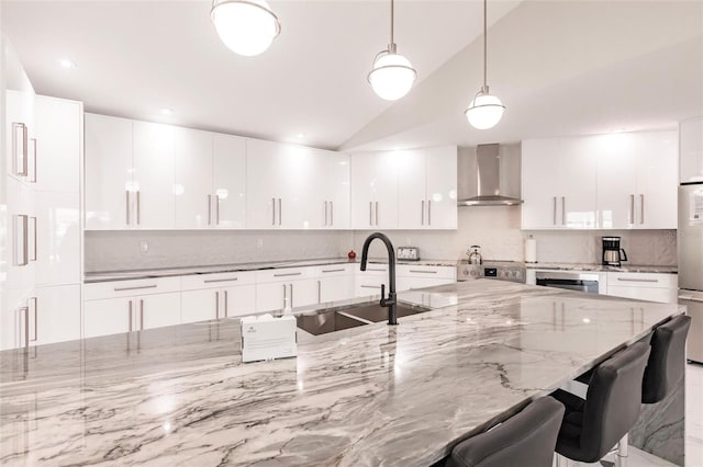 261 Venezia Ct, Punta Gorda, FL 33950 - kitchen featuring wall chimney range hood, a sink, modern cabinets, tasteful backsplash, and lofted ceiling