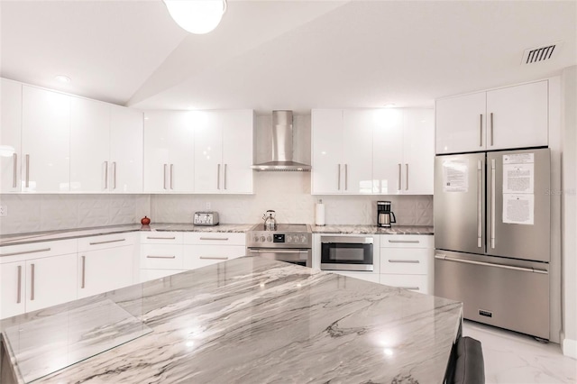 261 Venezia Ct, Punta Gorda, FL 33950 - kitchen featuring stainless steel appliances, wall chimney range hood, modern cabinets, white cabinetry, and tasteful backsplash