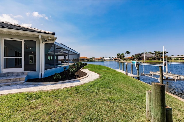 261 Venezia Ct, Punta Gorda, FL 33950 - view of green lawn with a water view, boat lift, a boat dock, and glass enclosure
