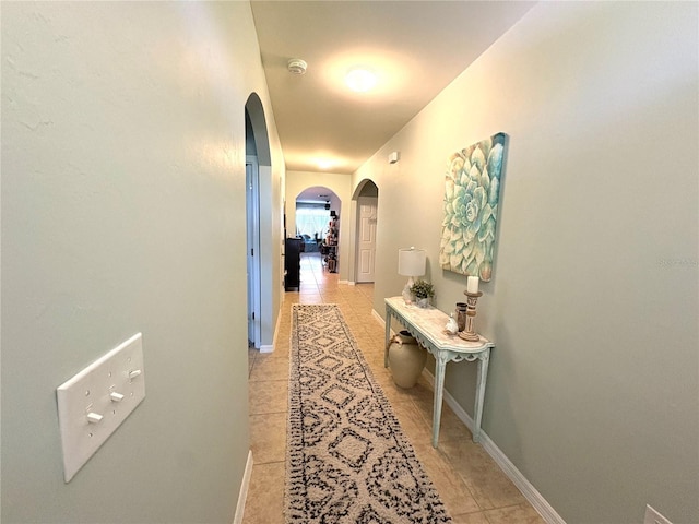 25008 Lalique Pl, Punta Gorda, FL 33950 - corridor featuring arched walkways, light tile patterned floors, and baseboards