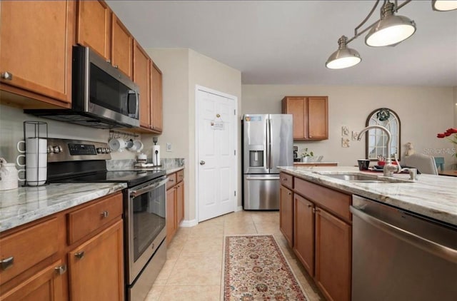 25008 Lalique Pl, Punta Gorda, FL 33950 - kitchen featuring stainless steel appliances, a sink, brown cabinets, and light tile patterned floors