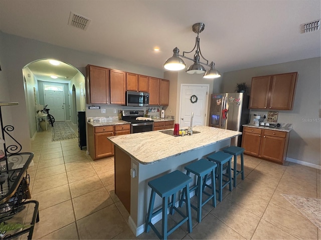 25008 Lalique Pl, Punta Gorda, FL 33950 - kitchen with appliances with stainless steel finishes, a sink, arched walkways, light countertops, and light tile patterned flooring