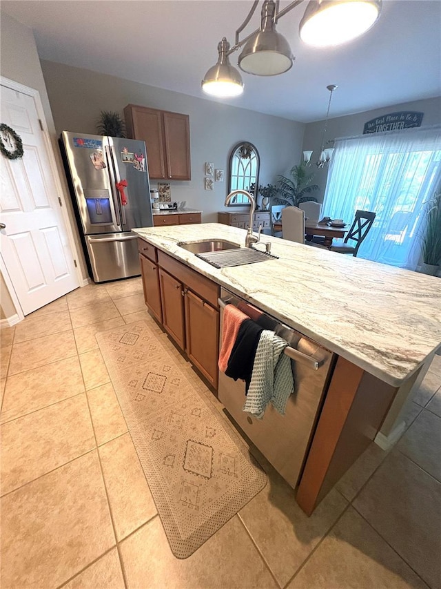 25008 Lalique Pl, Punta Gorda, FL 33950 - kitchen with appliances with stainless steel finishes, a sink, decorative light fixtures, light stone counters, and light tile patterned flooring