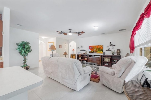 7652 Mikasa Dr, Punta Gorda, FL 33950 - living room with arched walkways, light tile patterned floors, and ceiling fan