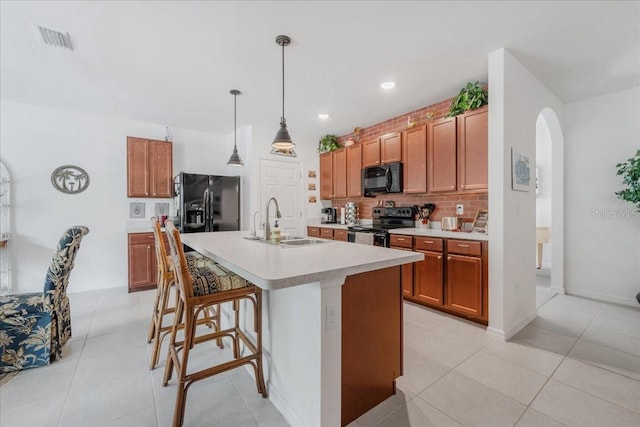 7652 Mikasa Dr, Punta Gorda, FL 33950 - kitchen with black appliances, a sink, brown cabinets, tasteful backsplash, and light countertops
