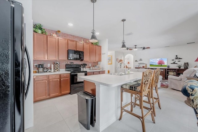 7652 Mikasa Dr, Punta Gorda, FL 33950 - kitchen featuring black appliances, open floor plan, a sink, light countertops, and backsplash