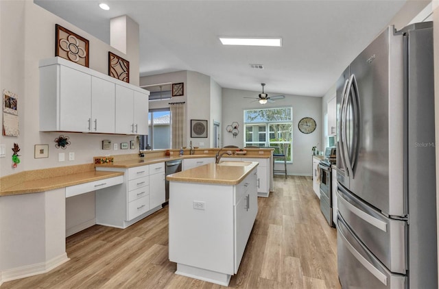 24358 Folkstone Ave, Punta Gorda, FL 33980 - kitchen with stainless steel appliances, a peninsula, light countertops, light wood-style flooring, and vaulted ceiling