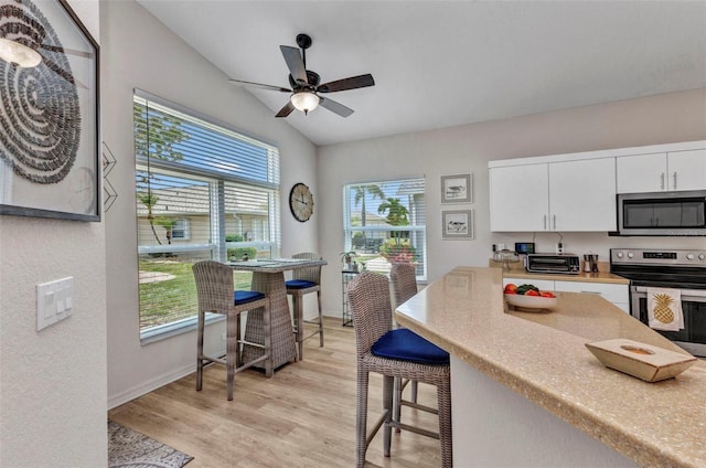 24358 Folkstone Ave, Punta Gorda, FL 33980 - kitchen featuring stainless steel appliances, light wood-style floors, light countertops, white cabinets, and a ceiling fan
