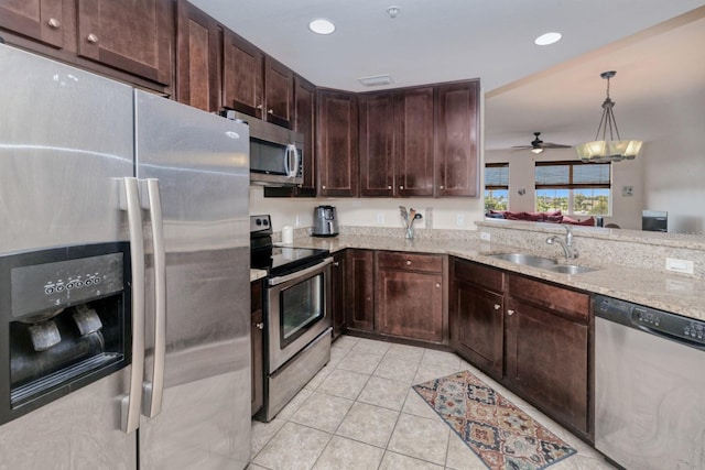 2001 Bal Harbor Blvd Unit 2306, Punta Gorda, FL 33950 - kitchen with stainless steel appliances, light tile patterned floors, light stone counters, dark brown cabinetry, and ceiling fan