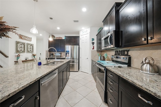 2515 Sherman Oak Dr, North Port, FL 34289 - kitchen featuring stainless steel appliances, a sink, light tile patterned floors, tasteful backsplash, and light stone counters
