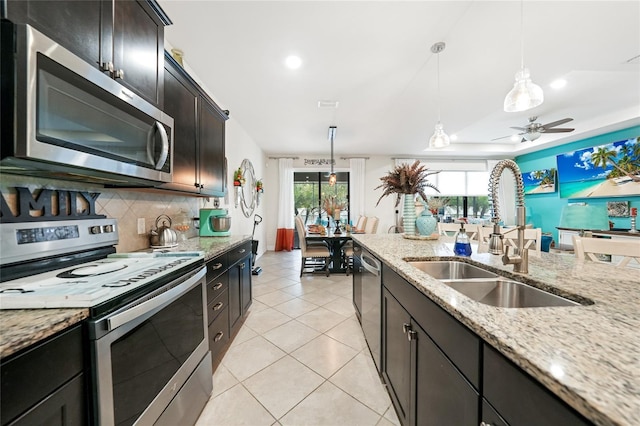 2515 Sherman Oak Dr, North Port, FL 34289 - kitchen featuring appliances with stainless steel finishes, a sink, tasteful backsplash, decorative light fixtures, and light stone counters