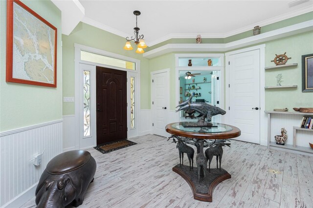 13204 Kakapo Ave, Port Charlotte, FL 33981 - foyer entrance with wood finished floors, wainscoting, and ornamental molding