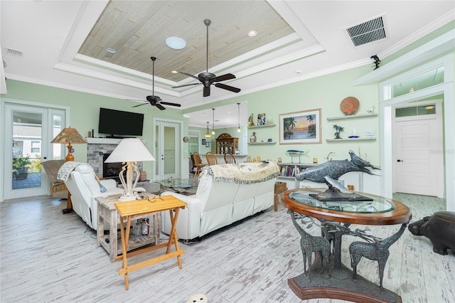 13204 Kakapo Ave, Port Charlotte, FL 33981 - living room featuring a tray ceiling, a fireplace, wood finished floors, and crown molding