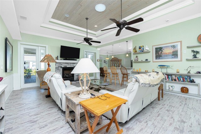 13204 Kakapo Ave, Port Charlotte, FL 33981 - living area with a raised ceiling, a stone fireplace, light wood-type flooring, ceiling fan, and ornamental molding
