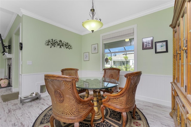 13204 Kakapo Ave, Port Charlotte, FL 33981 - dining room featuring a wainscoted wall, light wood-type flooring, and crown molding