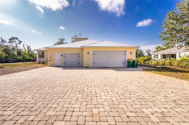 13204 Kakapo Ave, Port Charlotte, FL 33981 - view of front of property with decorative driveway, a standing seam roof, an attached garage, metal roof, and stucco siding