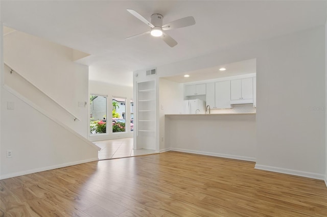 4346 Rayfield Dr Unit 4346, Sarasota, FL 34243 - unfurnished living room with light wood finished floors, ceiling fan, and baseboards