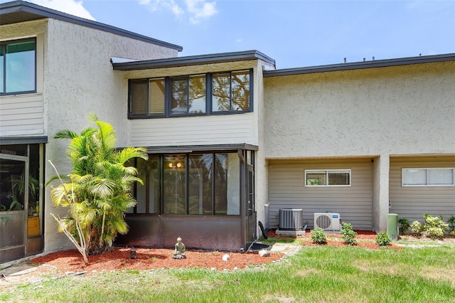 4346 Rayfield Dr Unit 4346, Sarasota, FL 34243 - back of property with a cooling unit, a sunroom, stucco siding, and central air condition unit