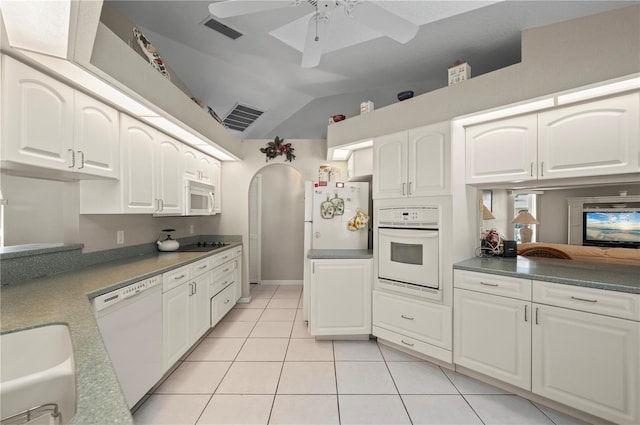 891 Bayard St, Port Charlotte, FL 33948 - kitchen with white appliances, vaulted ceiling, light tile patterned floors, arched walkways, and white cabinetry