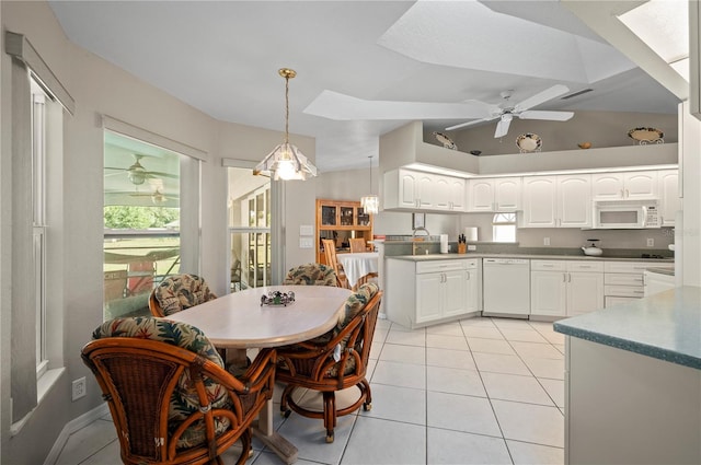891 Bayard St, Port Charlotte, FL 33948 - dining area featuring a skylight, ceiling fan, plenty of natural light, light tile patterned floors, and vaulted ceiling