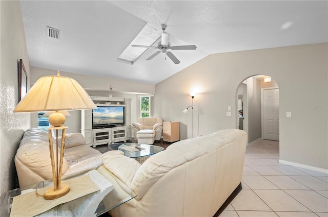 891 Bayard St, Port Charlotte, FL 33948 - living room with ceiling fan, vaulted ceiling, arched walkways, light tile patterned flooring, and baseboards