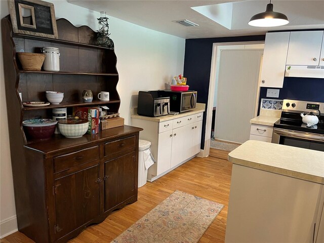 404 W Whidden St, Arcadia, FL 34266 - kitchen featuring appliances with stainless steel finishes, under cabinet range hood, light wood-style floors, white cabinets, and light countertops