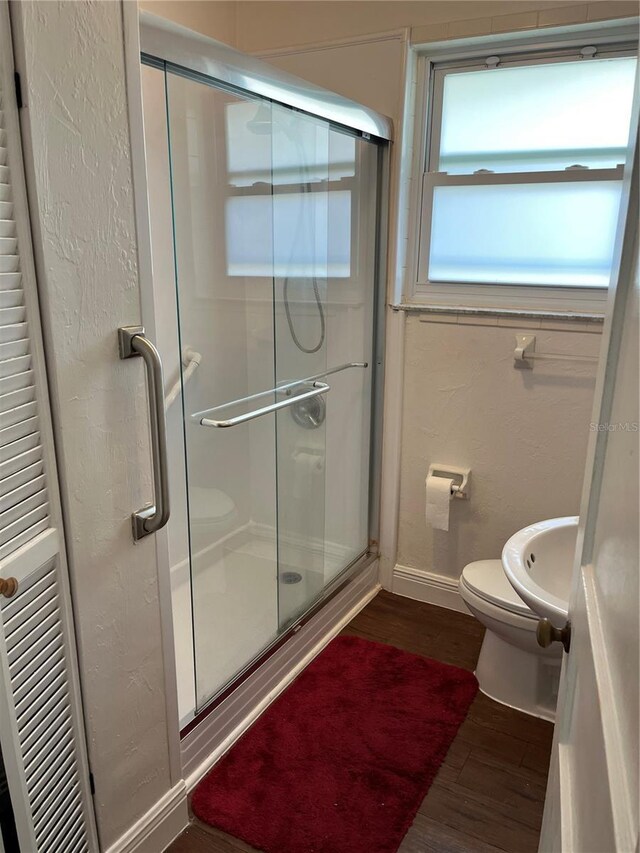 404 W Whidden St, Arcadia, FL 34266 - bathroom with wood finished floors, toilet, a stall shower, and baseboards