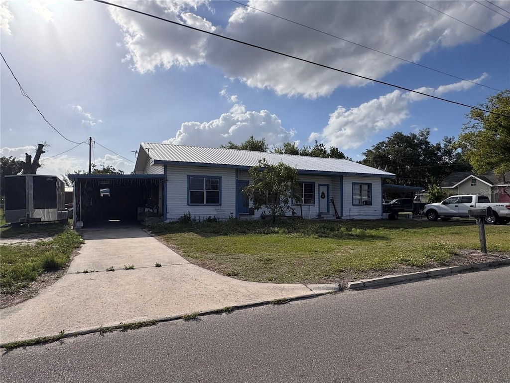 601 N Waldron St, Arcadia, FL 34266 - ranch-style house with driveway, a front yard, an attached carport, and a metal roof