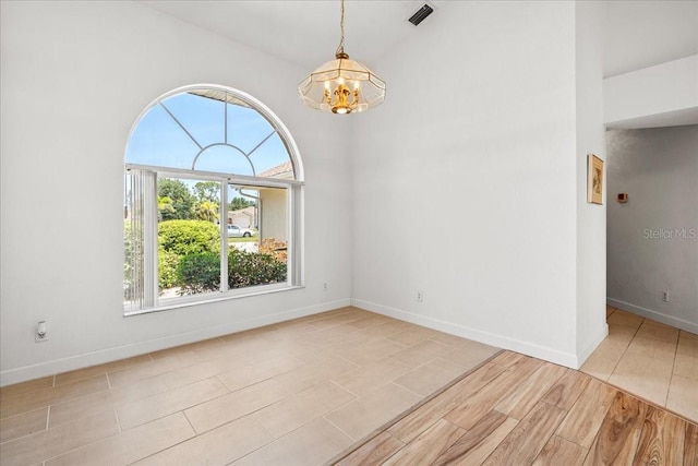 7334 N Tulip Tree, Punta Gorda, FL 33955 - empty room with a chandelier, baseboards, and wood finished floors