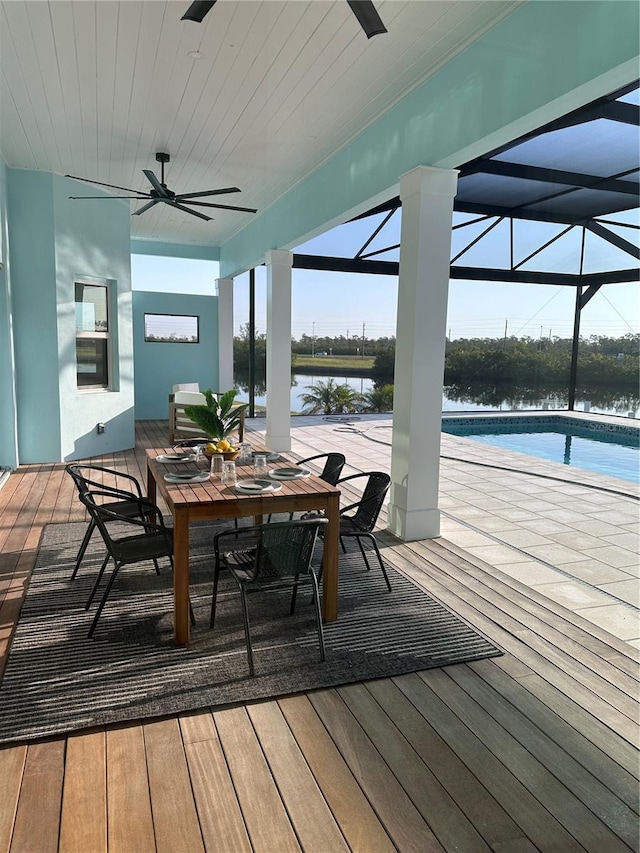 3548 Mondovi Ct, Punta Gorda, FL 33950 - wooden terrace with ceiling fan, outdoor dining space, an outdoor pool, a water view, and glass enclosure