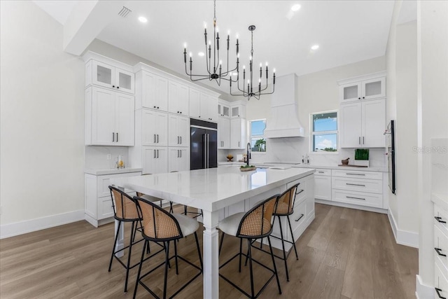 3548 Mondovi Ct, Punta Gorda, FL 33950 - kitchen with paneled built in fridge, a chandelier, a kitchen breakfast bar, wood finished floors, and recessed lighting
