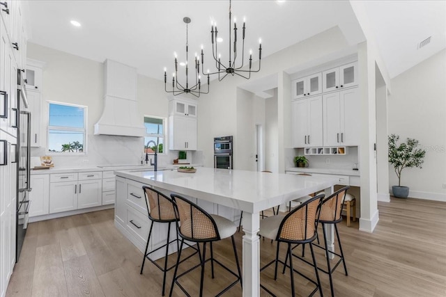 3548 Mondovi Ct, Punta Gorda, FL 33950 - kitchen featuring a spacious island, a kitchen breakfast bar, white cabinets, double oven, and recessed lighting