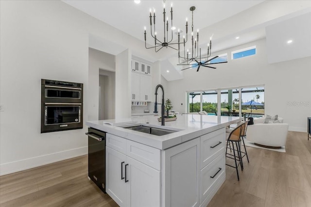3548 Mondovi Ct, Punta Gorda, FL 33950 - kitchen with a chandelier, open floor plan, light countertops, an island with sink, and white cabinetry