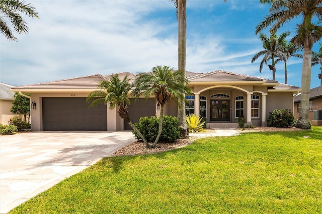 523 Saint Girons Ct, Punta Gorda, FL 33950 - mediterranean / spanish home with stucco siding, a front yard, an attached garage, driveway, and a tiled roof