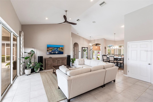 523 Saint Girons Ct, Punta Gorda, FL 33950 - living room with arched walkways, a ceiling fan, light tile patterned floors, high vaulted ceiling, and a chandelier
